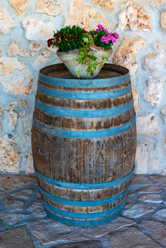 Large flower pot with white chrysanthemums. Vase with flowers stand on wooden barrel