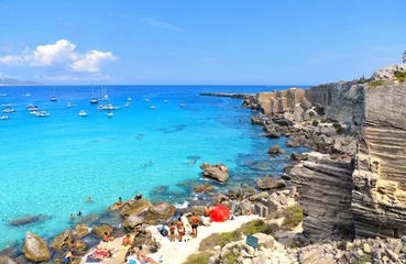 Fotobehang people inside paradise clear torquoise blue water with boats and cloudy blue sky in background in Favignana island, Cala Rossa Beach, Sicily South Italy. © poludziber