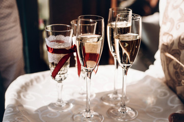 champagne glasses on tray at wedding reception, celebration outdoors, catering in restaurant. christmas and new year