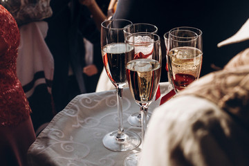champagne glasses on tray at wedding reception, celebration outdoors, catering in restaurant. christmas and new year