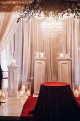 candles in glass lanterns and arch, stylish wedding decor for evening wedding ceremony in garden, light close up. beautiful romantic place for love celebration