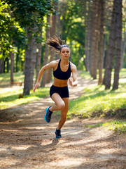 Active young brunette woman running in park, summer, healthy, perfect tone body. Workout outside. Lifestyle concept.