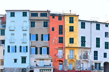 Fototapeta na wymiar Picturesque panorama with colorful houses with windows and balcony against blue sky in Porto Venere, Italy, Liguria