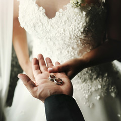 wedding couple holding luxury wedding rings, groom showing bride wedding rings on hand in morning hotel room