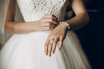 Obraz na płótnie Canvas bride putting on luxury bracelet on hand in the morning, getting ready