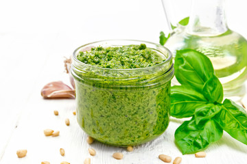Pesto in glass jar on board