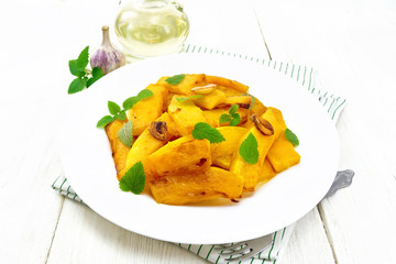 Pumpkin with garlic and mint in plate on light board