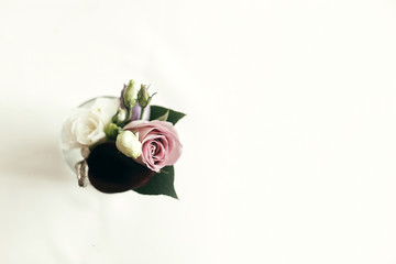 stylish rustic boutonniere on white table with space for text, top view. arrangements for wedding...