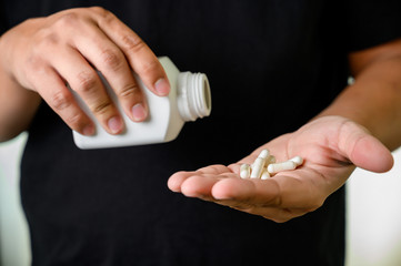 man hand holding frug medicine bottle on Herbal supplement pill eating healthy