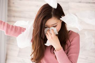 ティッシュで鼻をかむ女性	
