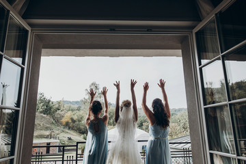luxury gorgeous bride and her bridesmaids having fun in hotel room, at window, wedding morning....