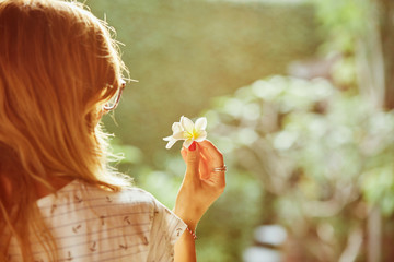 Portrait of beautiful woman holding frangipani flowers.