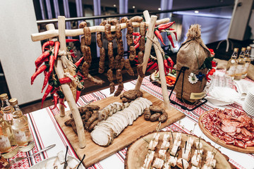 meat table at luxury wedding reception. ham,bacon,sausages,salami,prosciutto,lard on wooden desk. expensive catering at celebration, birthday, shower, christmas. space for text