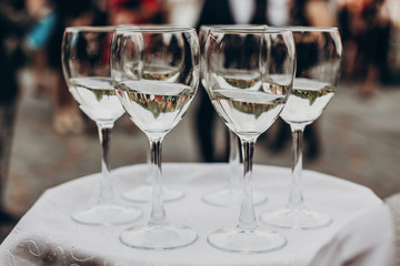 champagne and wine glasses on tray at luxury wedding reception at restaurant.  waiter serving drinks among guests at stylish celebration. luxury life concept. space for text