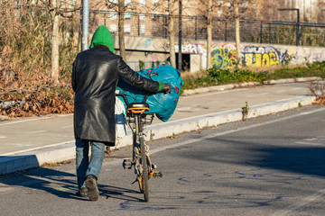 Homeless African migrant in Rome. Urban poverty, dawn of a city, beggar going off with a stolen...