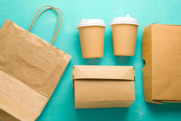 op view flat lay recyclable types of paper  packaging on a blue background, paper bag, disposable glass, cardboard box