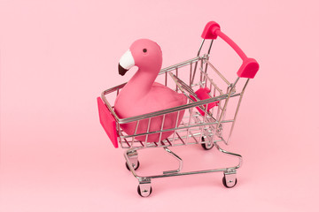 shopping cart with flamingo on pink pastel background