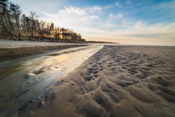 Fast stream on the shore of a Baltic sea at sunset