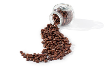 Coffee beans scattered in a beautiful wave from transparent glass jar on a white background isolated close up top view