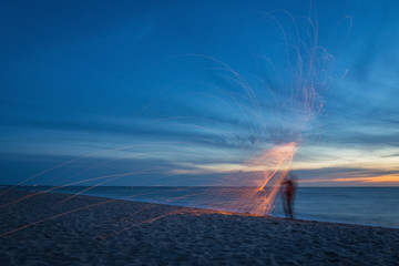 Light painting with steel wool on the beach after the sunset