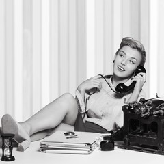 Attractive young woman speaking on vintage phone