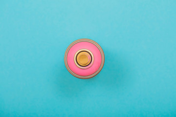 pink spray can on cyan background 