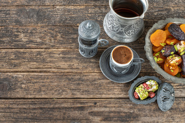 Obraz na płótnie Canvas Turkish Coffee in the authentic cup and water on the handmade carpet with dry fruits
