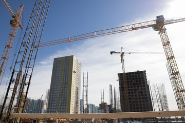 Concrete pillars on construction site. Building of skyscraper with crane, tools and reinforced...