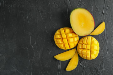 Flat lay composition with cut mangoes and space for text on black background