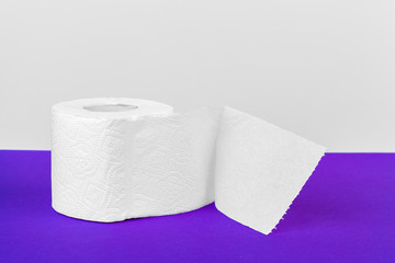 Toilet paper rolls isolated on white table with purple background