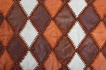 Fototapeta premium Pieces of multi-colored leather stitched with thread. Leather texture, background, haberdashery, sew clothes and bag.