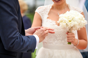 Happy groom put the rings on bride hand