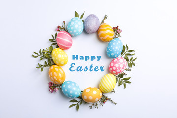Decorative Easter eggs and flowers on white background, space for text. Top view