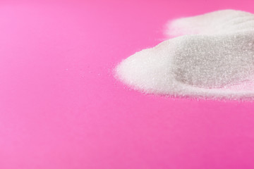 White sugar on a pink background top view