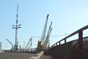 Fototapeta na wymiar Odessa seaport, Odessa, Ukraine. Cranes and ships in the port against a background of blue sky.
