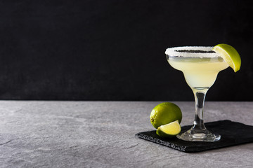 Margarita cocktails with lime in glass on gray background. Copyspace