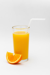 a glass of orange juice and a slice of orange on a white background