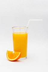 a glass of orange juice and a slice of orange on a white background