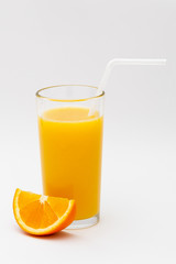 a glass of orange juice and a slice of orange on a white background