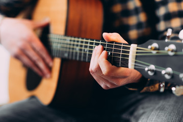 Guitar player. Selective focus of male fingers touching strings while playing the guitar