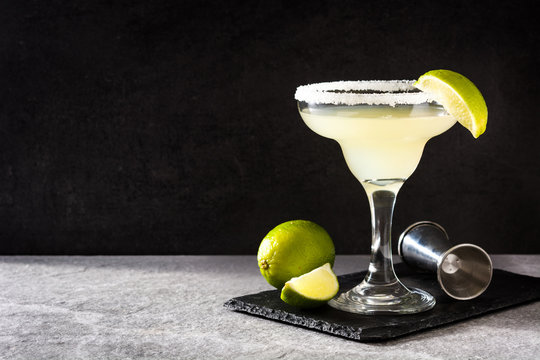 Margarita cocktails with lime in glass on gray background. Copyspace