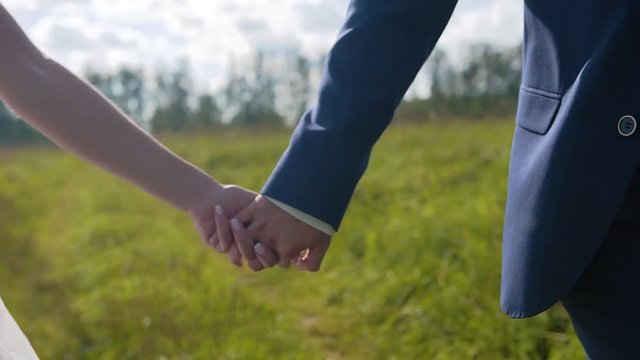 Lovers boy and girl holding hands running along the forest road. Beautiful plan in motion. Slow motion. Beautiful scenery. Love