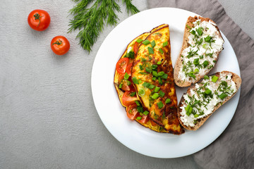 Omelette with cherry tomatoes, toasts with cream cheese and greenery