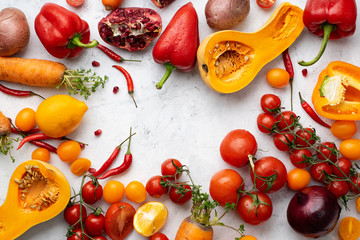 Flatlay with colorful vegetables and copy space arranged on white background. Tomatoes, squash and peppers. Frame shape with space in centre. Vegan nutrition concept