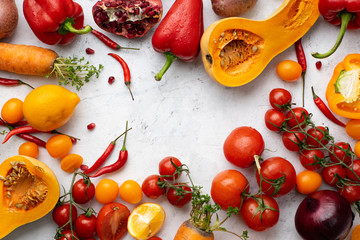 Flatlay with colorful vegetables and copy space arranged on white background. Tomatoes, squash and peppers. Frame shape with space in centre. Vegan nutrition concept