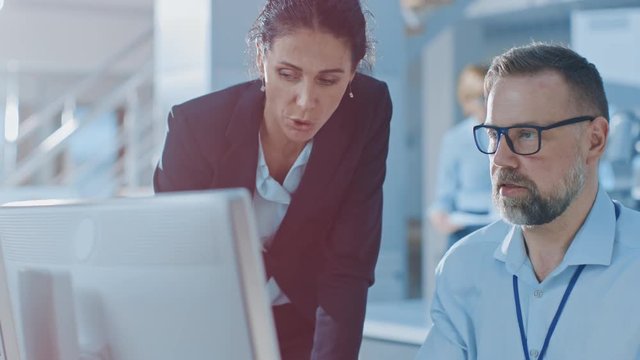 Female Chief Engineer Talks with Electronics Specialist, Explaining Things, He Works on Computer and Agrees with Her. Modern and Bright Office with Stylish People 