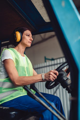 Woman forklift operator driving vehicle