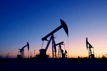 Oil pumps in action, silhouetted against the setting sun
