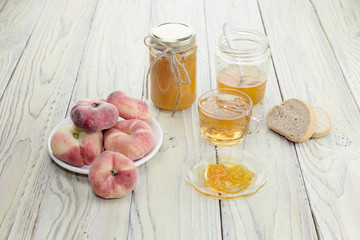 Peach jam, tea and bread close-up on a wooden table