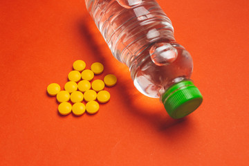 top view of yellow pills and a water bottle